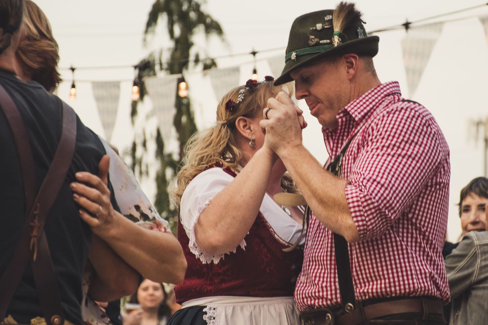 Casal com trajes típicos alemães dançando durante uma festa