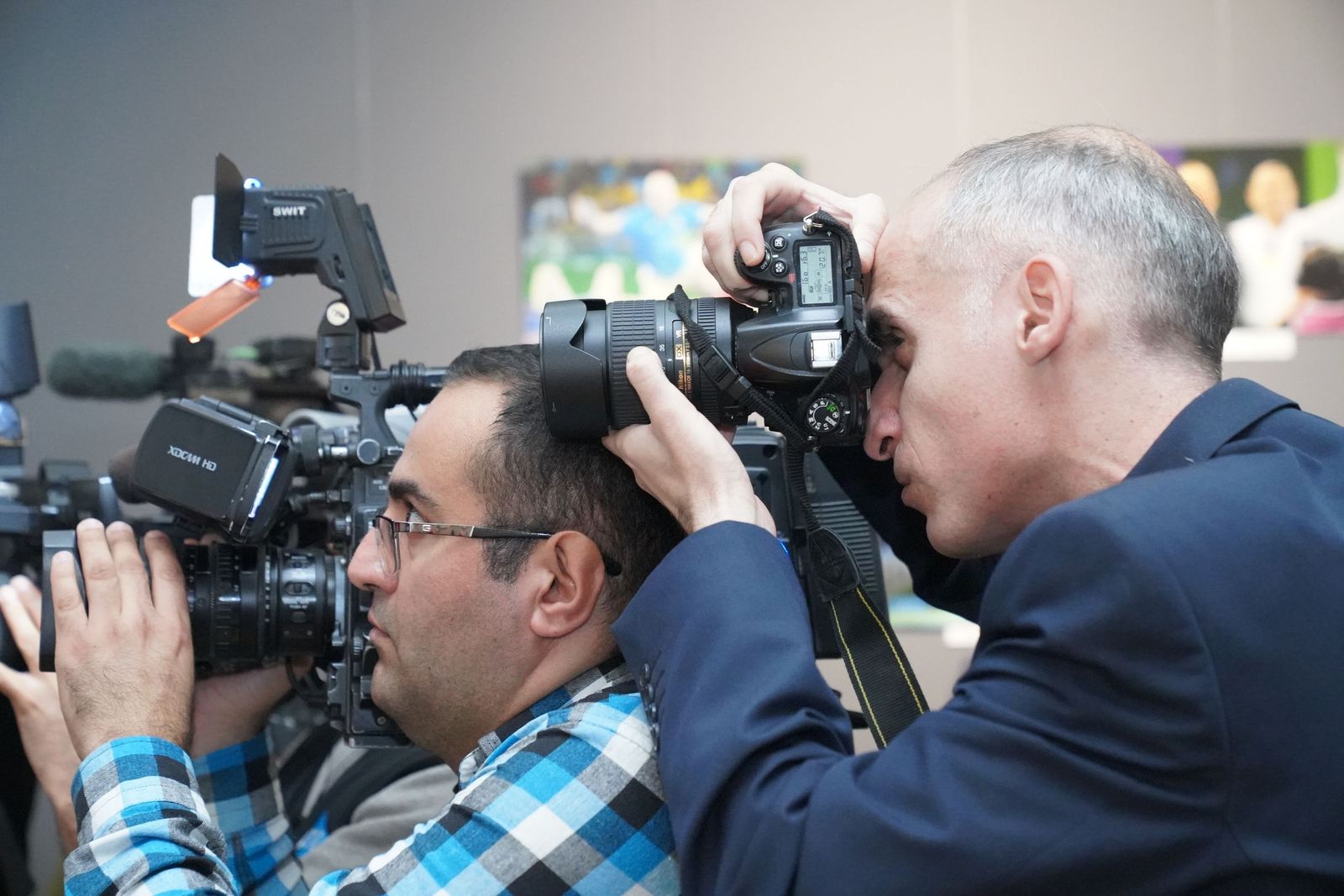 Fotógrafo e cinegrafista registrando um evento com suas câmeras